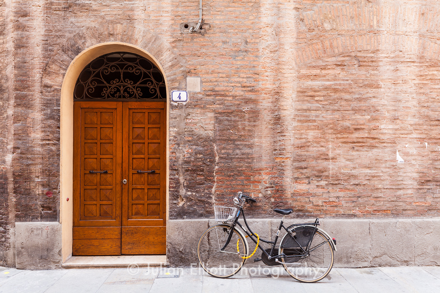 An old door and bicycle in Modena, Italy.