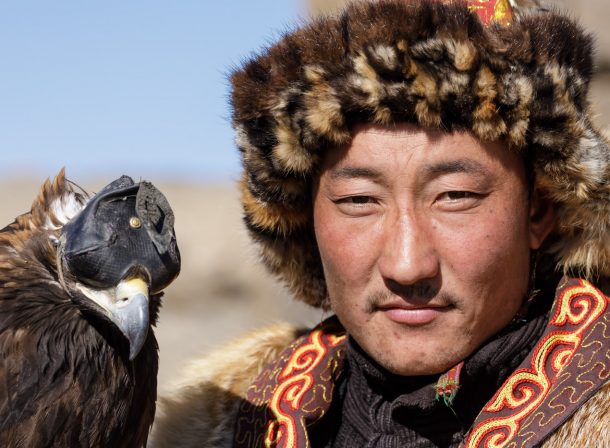 A Kazak Mongolian eagle hunter and his eagle in the Altai