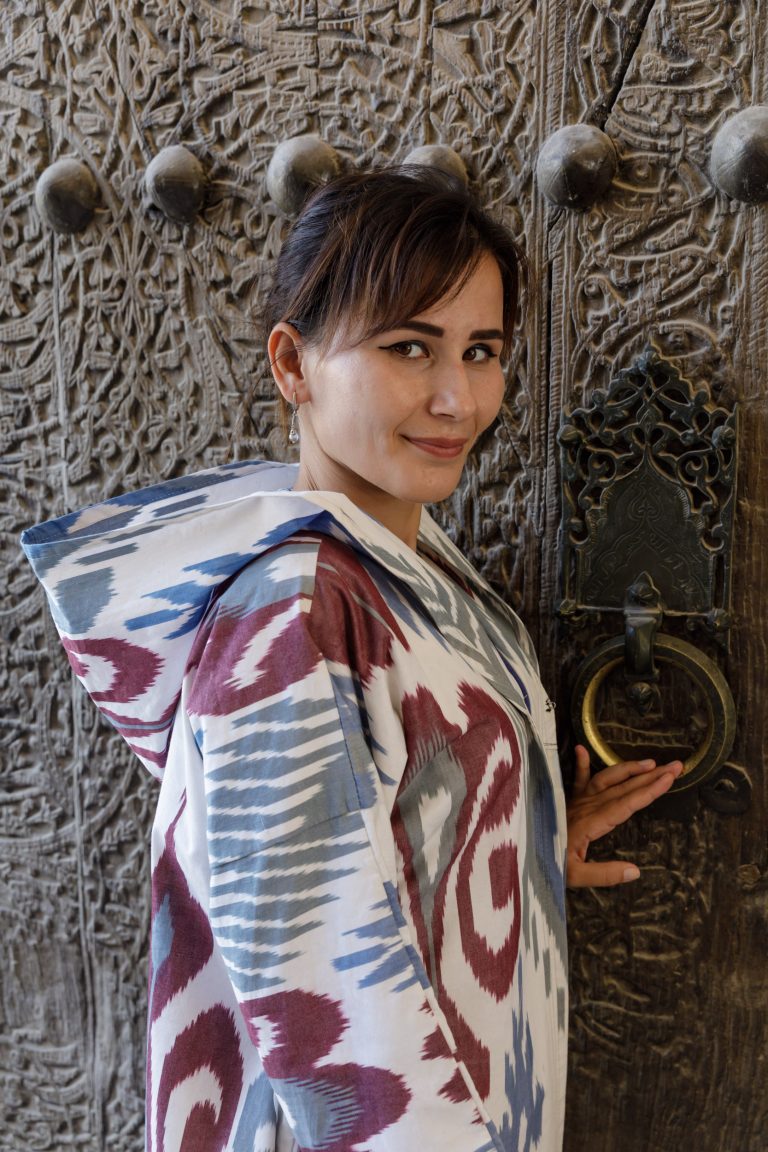 A beautiful Uzbek woman in traditional clothes in the old city of Khiva, Uzbekistan.