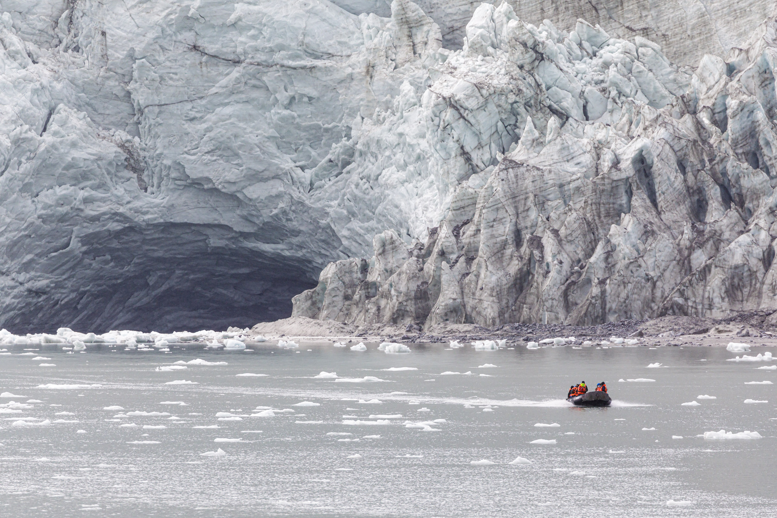 A zodiac boat is dwarfed by Pia Glacier in Tierra del Fuego, Patagonia, Chile.