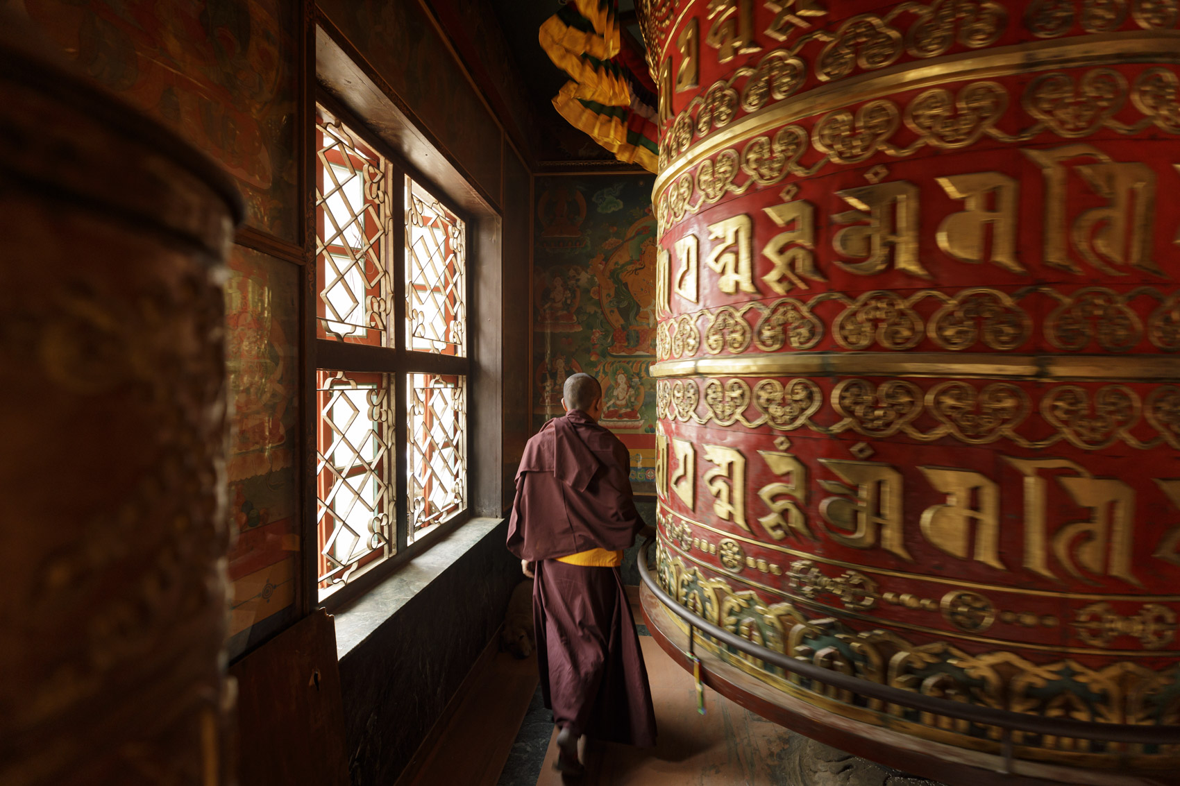 A monk turns a prayer wheel