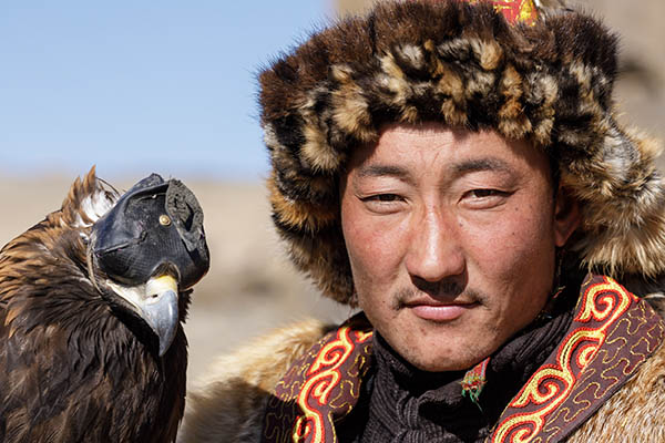 A Kazak Mongolian eagle hunter and his eagle in the Altai