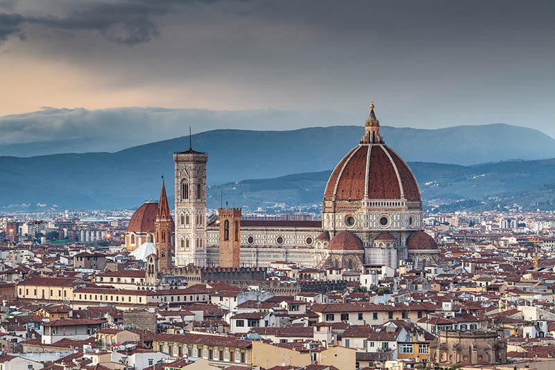 The view from Piazzale Michelangelo over to the historic city of Florence at dusk. The historic centre is protected by UNESCO as a World Heritage Site. The dome of Basilica di Santa Maria del Fiore otherwise known as the Duomo can be seen.