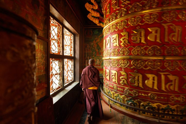 A monk turns a prayer wheel in Nepal. photography tour