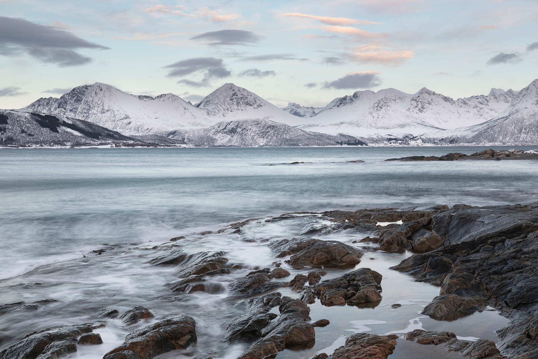 Snow covered mountains around the coastline near the island of Sommaroy in northern Norway.