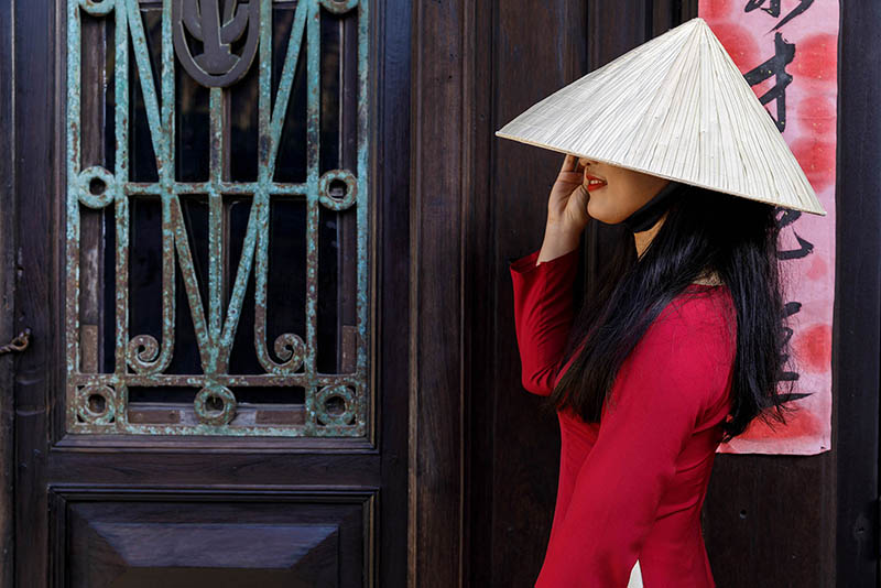 A young Vietnamese woman wearing the traditional Ao Dai dress in Hoi An, Vietnam.