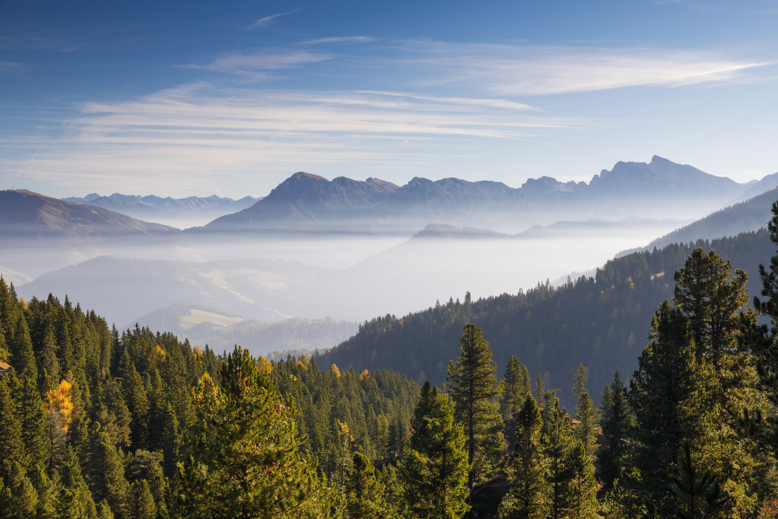 A mist covered valley illuminated by the morning light in the Dolomites of northern Italy.
