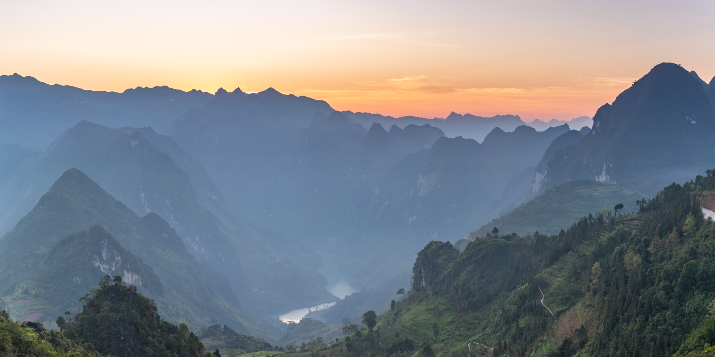 Panoramic image of the sunrise across the beautiful mountainous landscape of Ha Giang in northern Vietnam.
