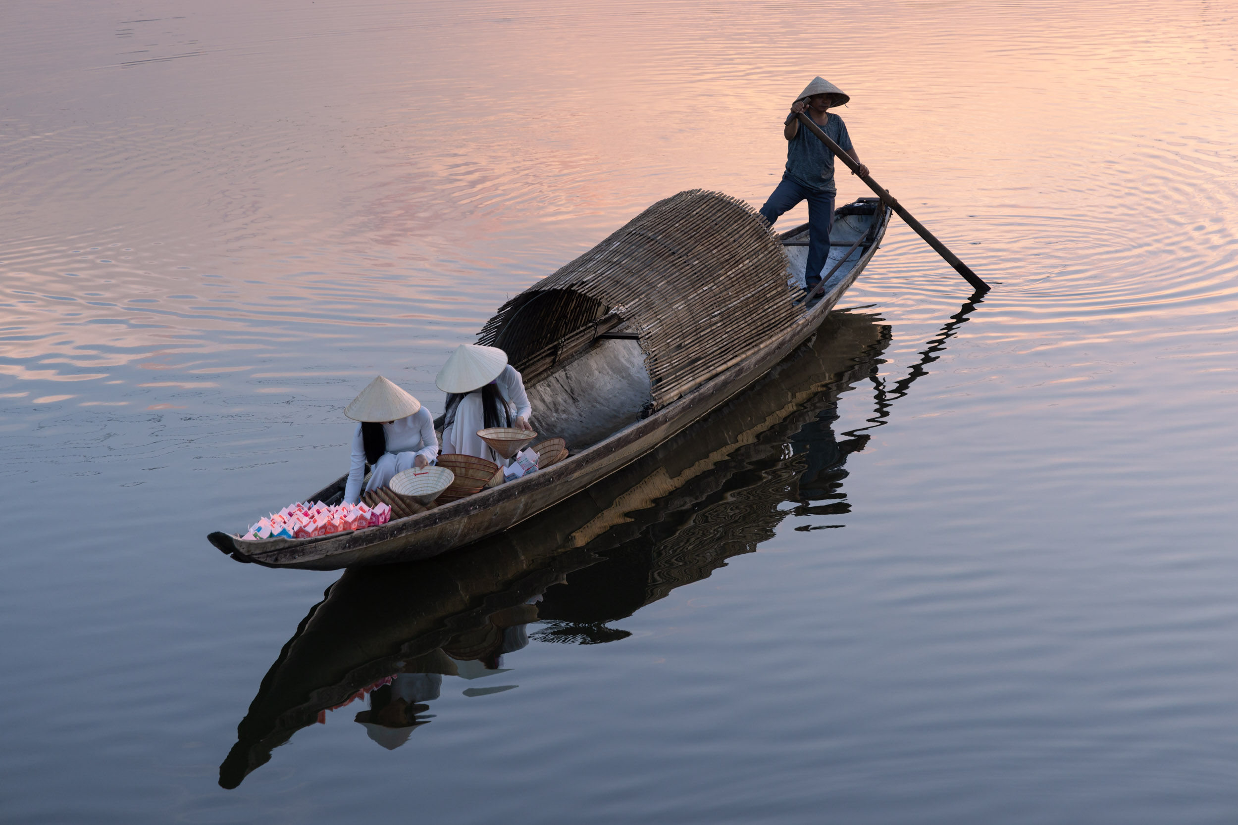 Two beautiful Vietnamese girls in Ao Dai (traditional dress) getting ready to float lanterns on the Perfume River in Hue, Vietnam.