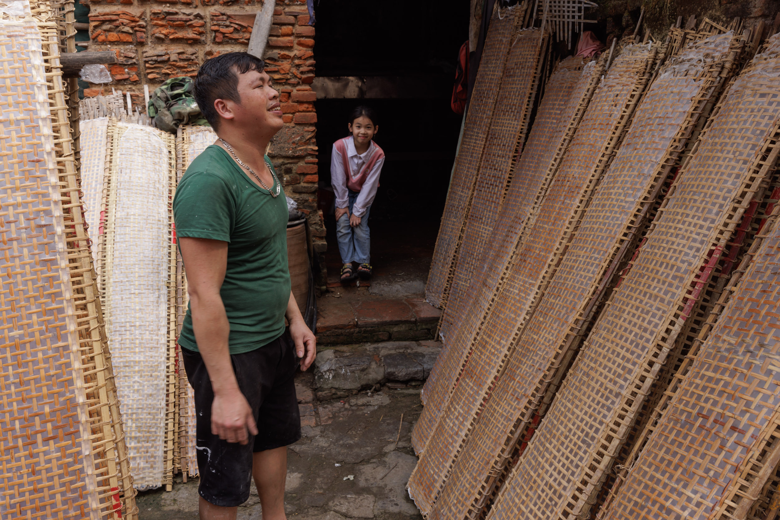 A man inspects rice paper rolls drying in Tho Ha village, Bac Ninh province, Vietnam.