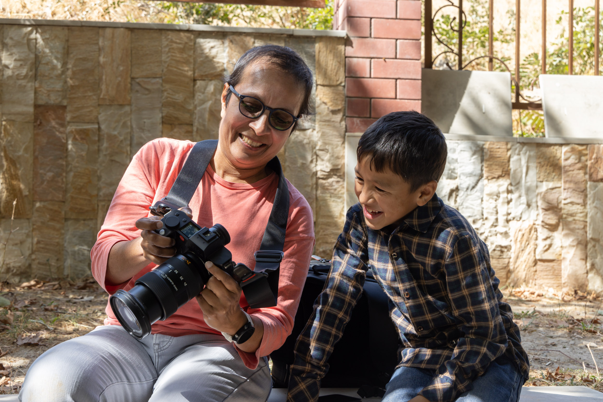 A photographer shows a young Uzbek boy his portrait shots.