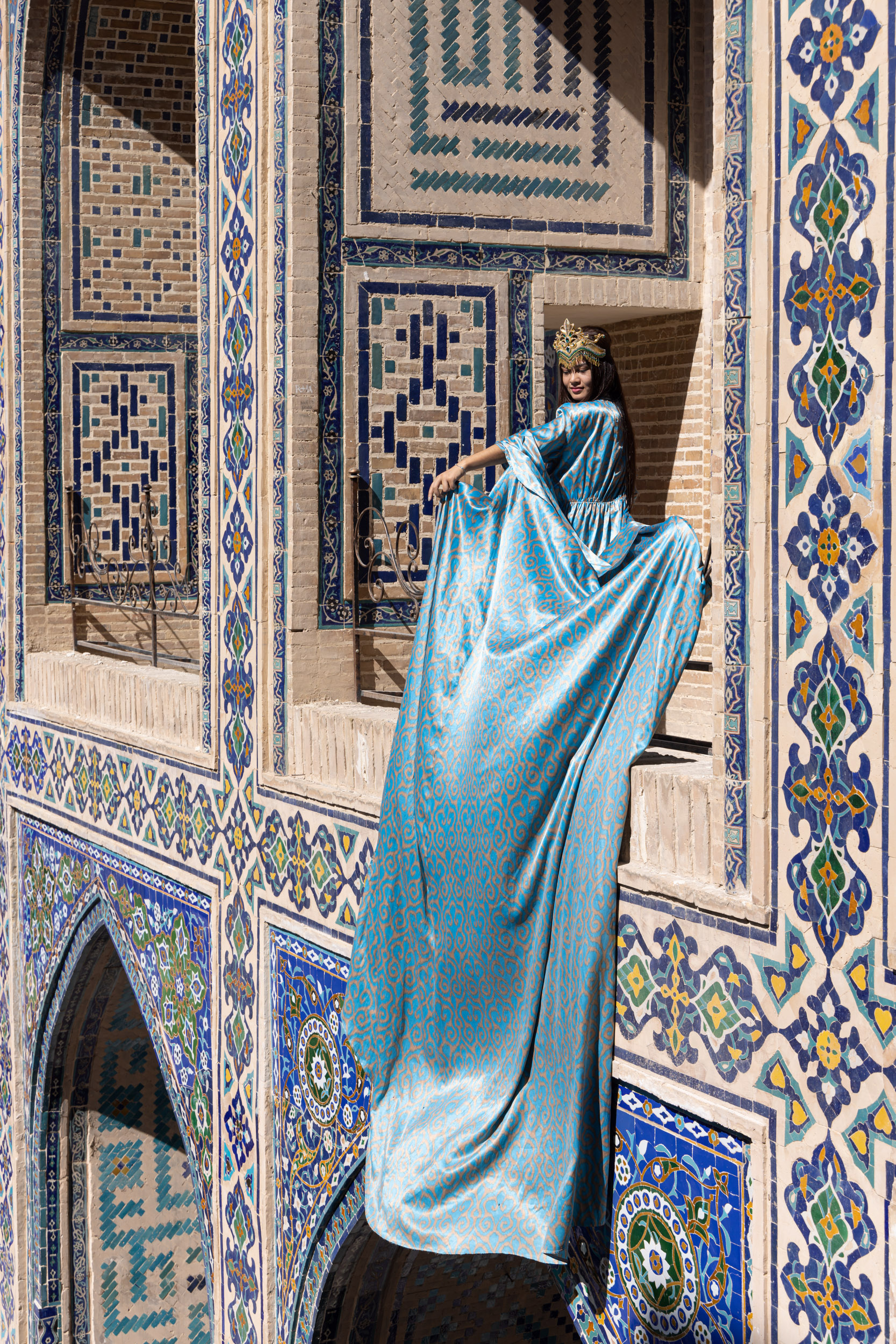 A beautiful young Uzbek woman wearing traditional dress on Registan Square in Samarkand, Uzbekistan.