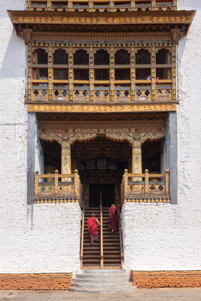 Two monks climbing stairs in Punakha Dzong in Punakha, Bhutan.