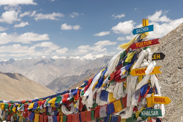 A prayer flag covered sign on top of the Khardungla pass of Ladakh near to Leh, India.