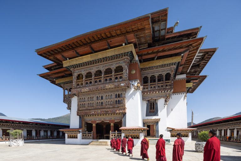 Monks walking into Gangtey Monastery in Bhutan. August 2024 newsletter cover.
