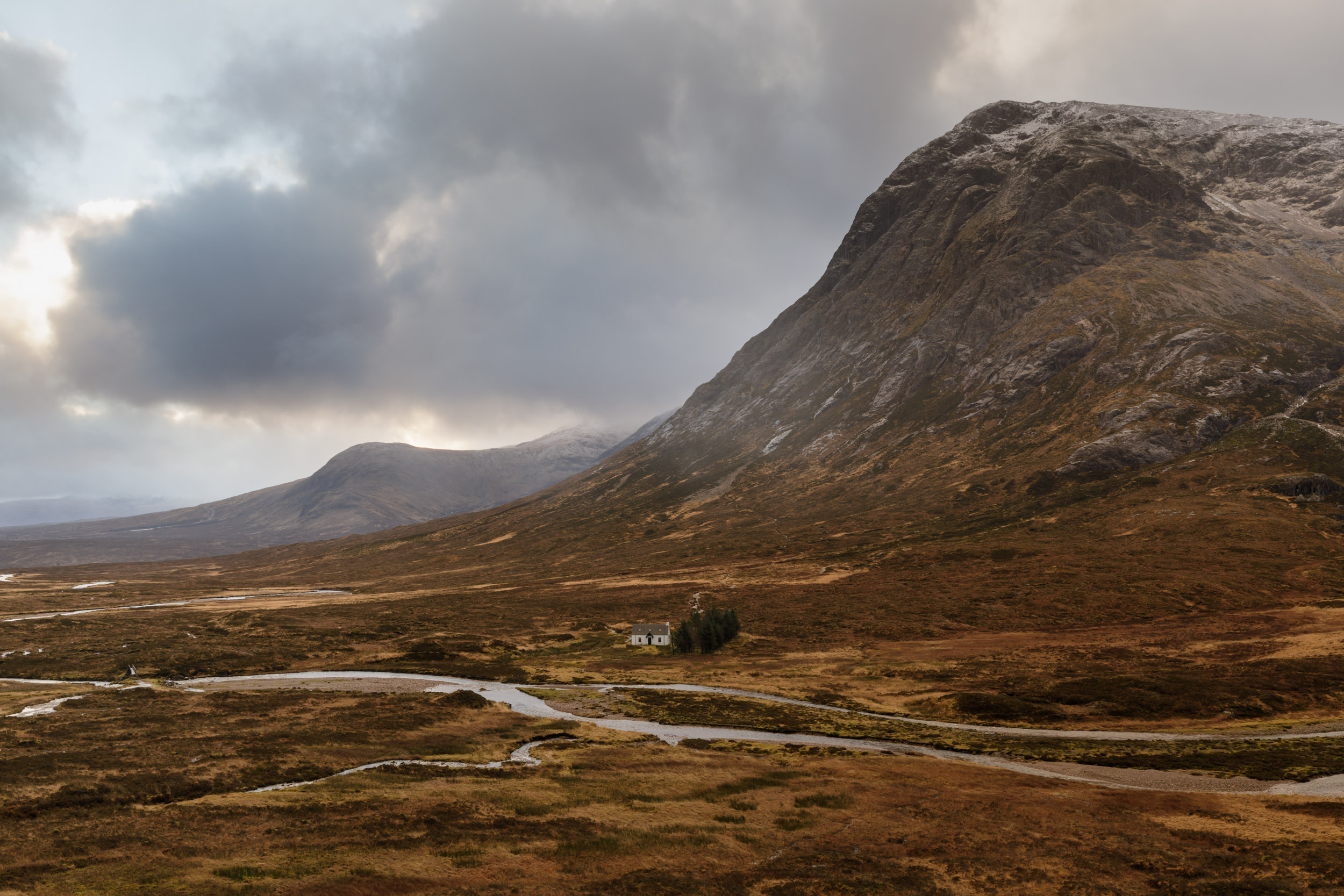 Dark storm clouds over Lagangarbh Cottage and Buachaille Etive Mor, Rannoch Mor, Scotland.