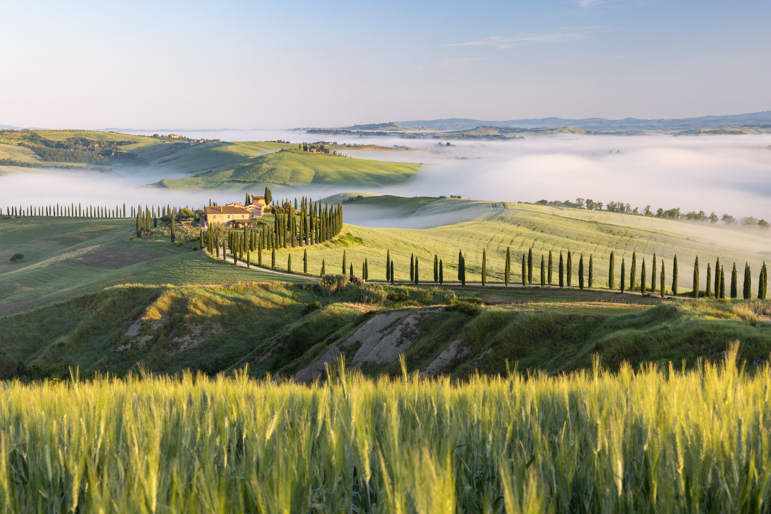 A lone farmhouse at sunrise in the Crete Senesi, Tuscany, Italy.