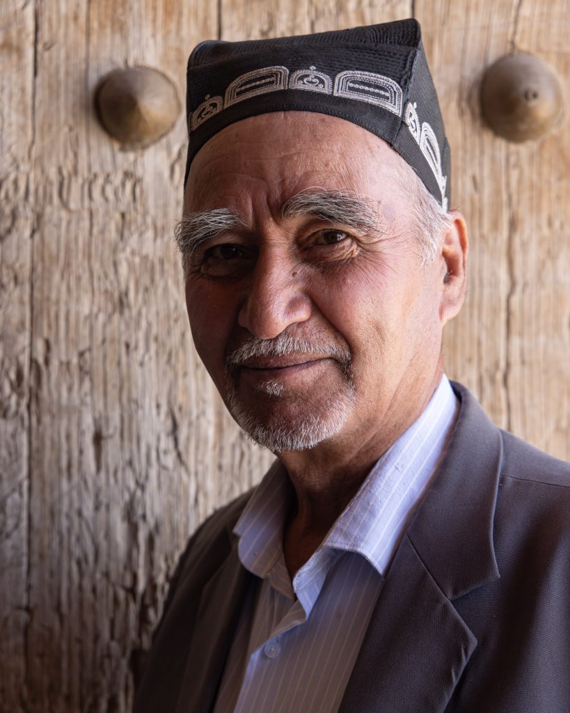 An Uzbek man poses against the ornate doors of Ulli Hovli near to Urgench, Uzbekistan.