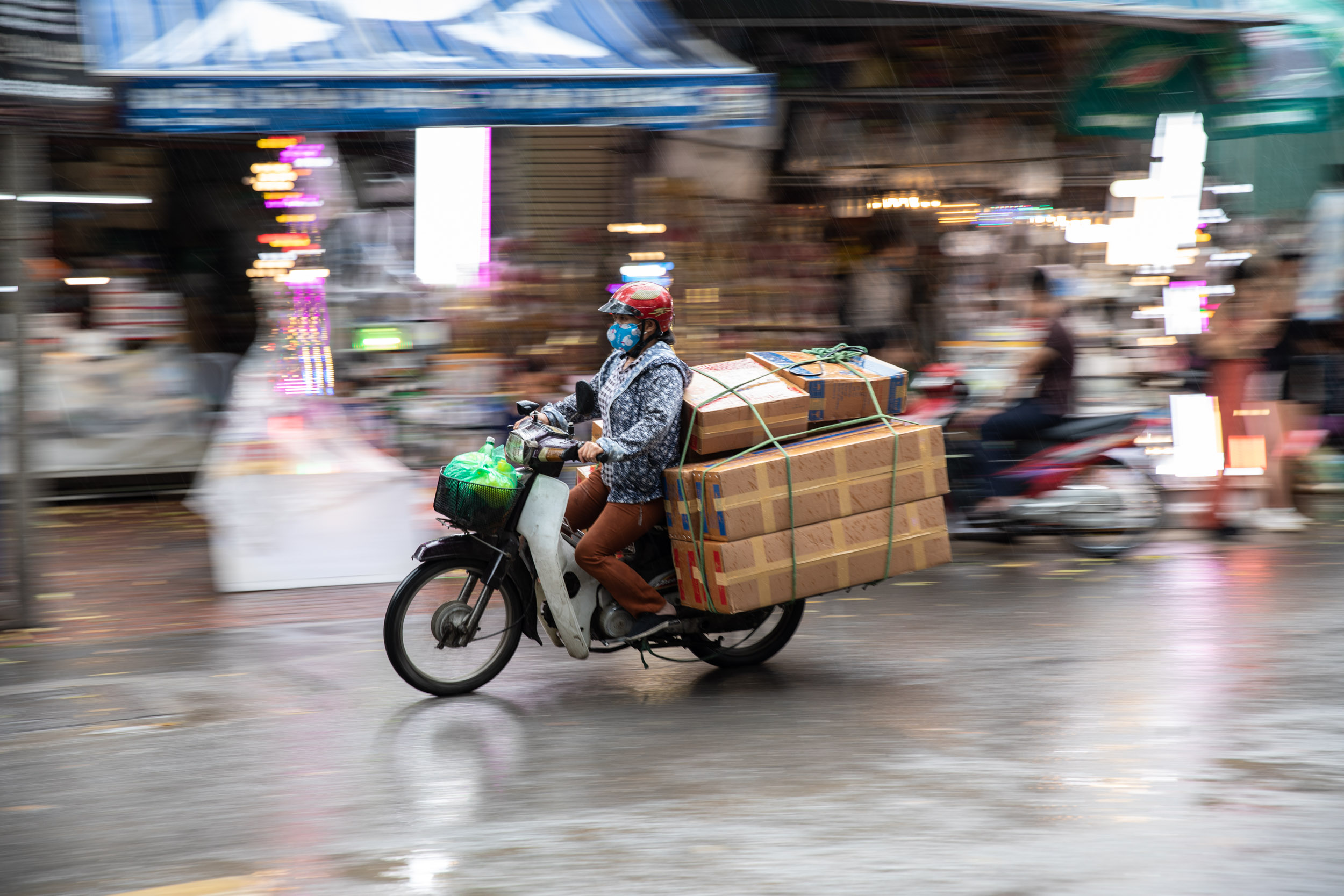 A woman transporting goods through the streets of Hanoi, Vietnam.