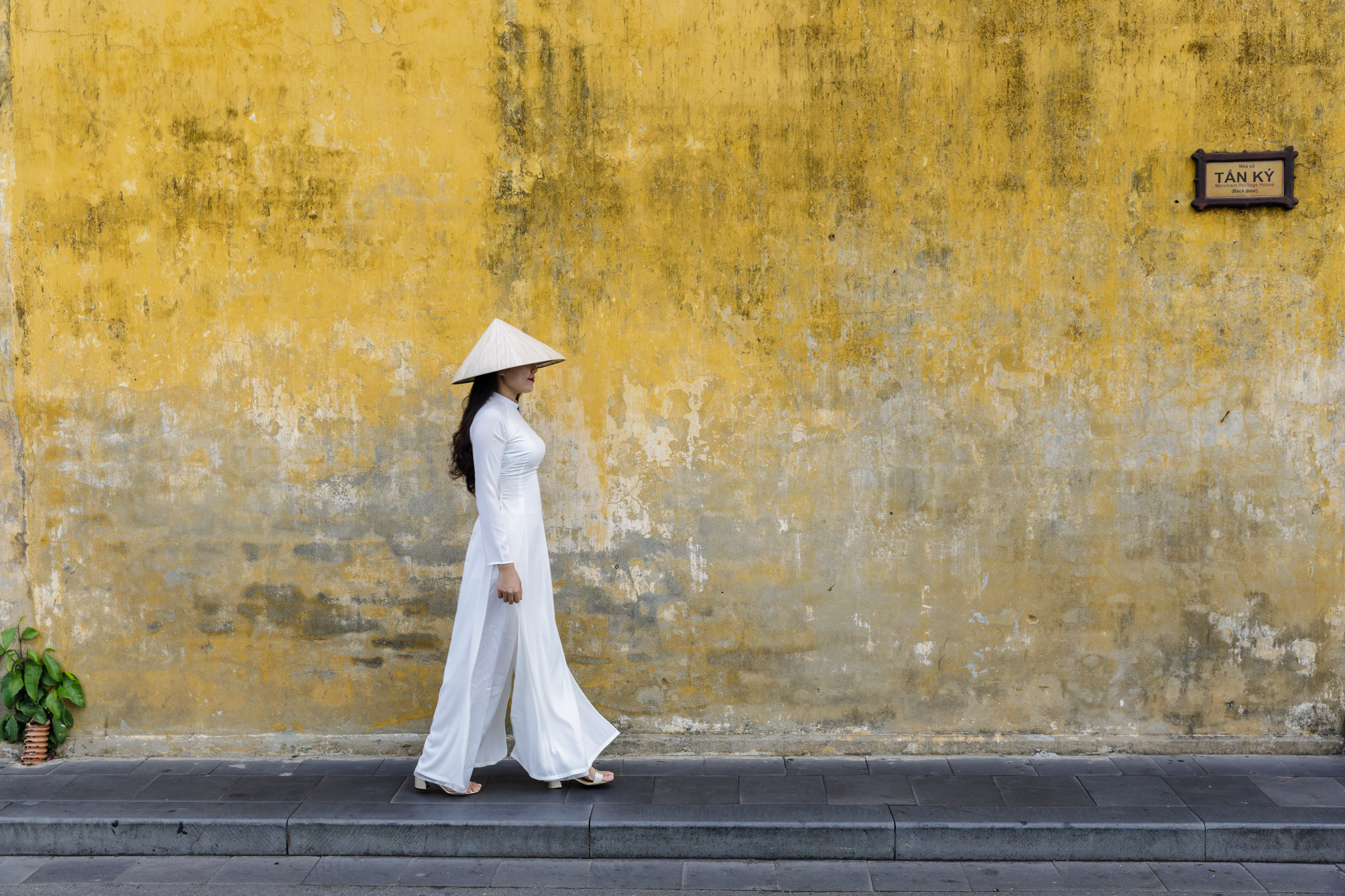A young Vietnamese woman wearing the traditional Ao Dai dress in Hoi An, Vietnam.