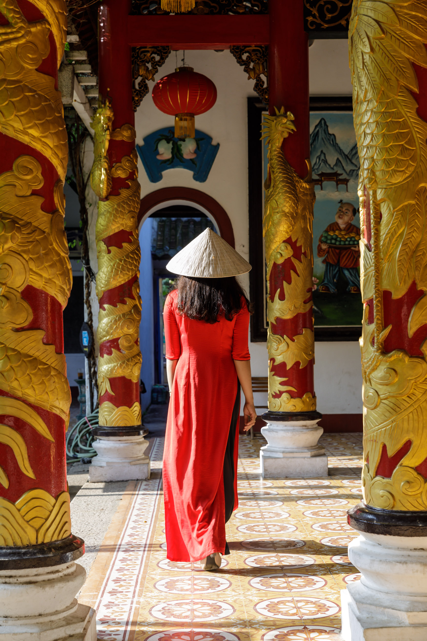 A young Vietnamese woman wearing the traditional Ao Dai dress in Guang Gong Temple, Hoi An, Vietnam.