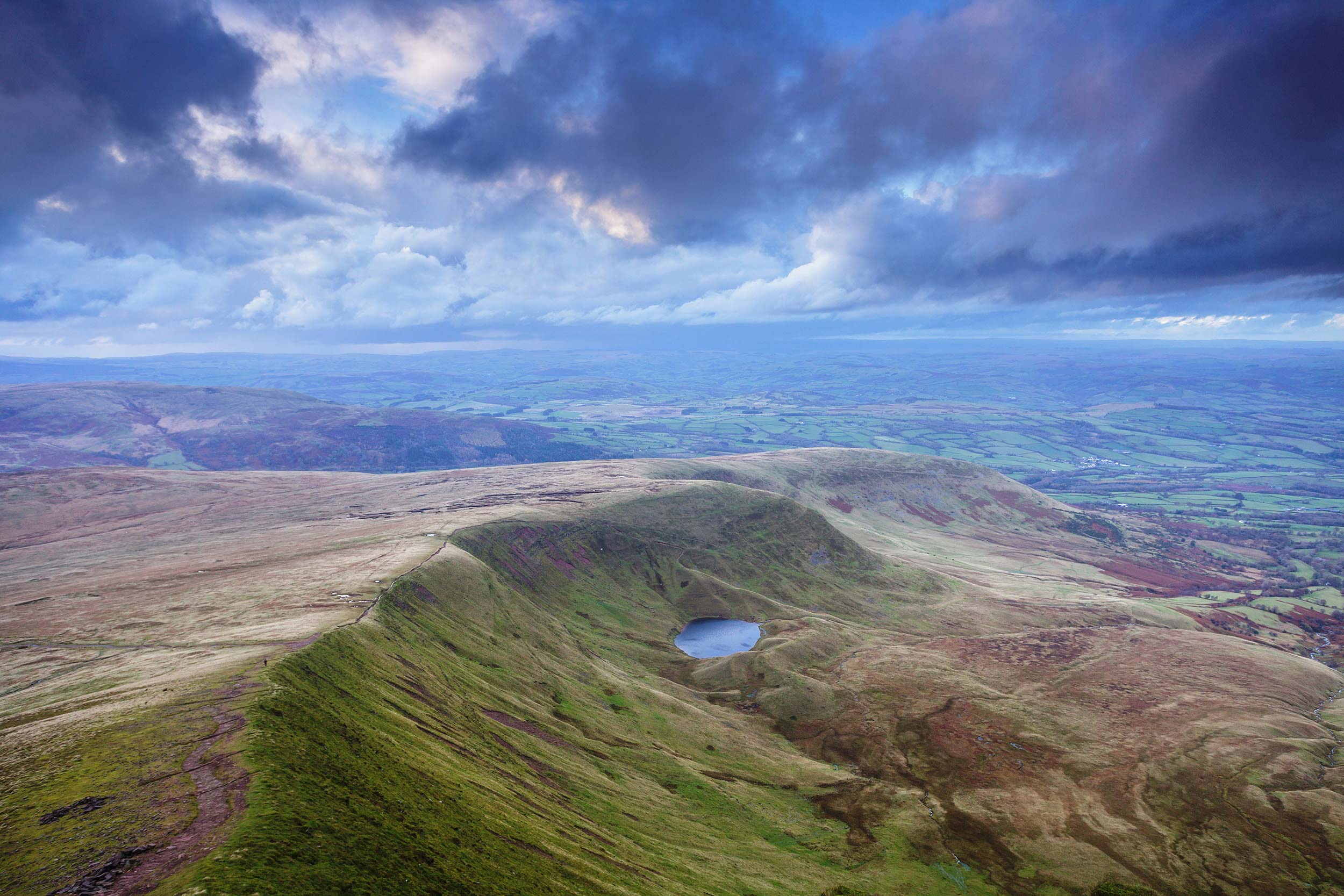 Storm clouds over Craig Cwm Llwch in the Brecon Beacons national park. Landscape photos gallery. Print by Julian Elliott Photography.
