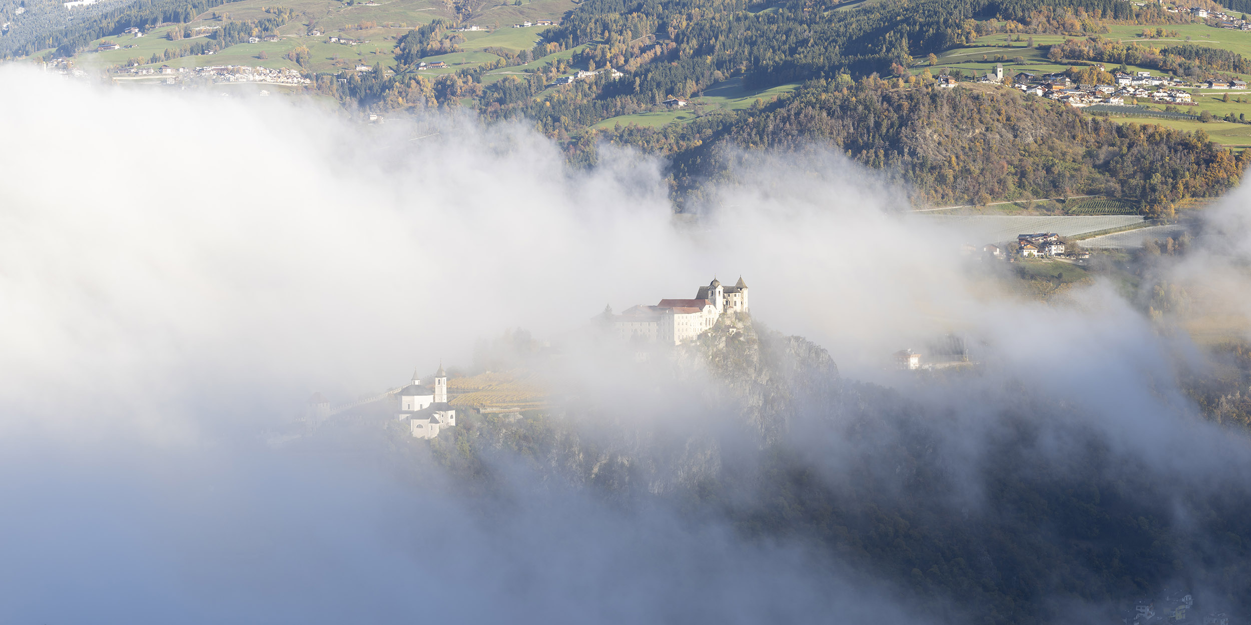 Panorama of the beautiful morning mist surrounding Saben abbey in South Tyrol. Taken during the dolomites photo tour.