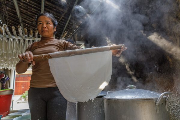 A woman making banh cuon