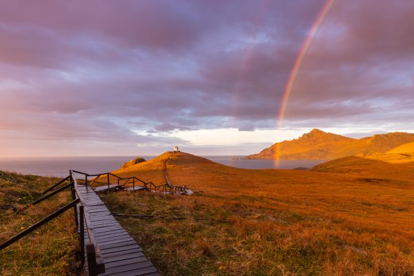 A fiery sunrise and double rainbow across Hornos Island