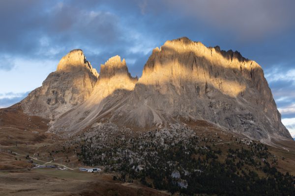 The rising sun illuminating the craggy mountains of Sassolungo and Passo Gardena, Italy. Dolomites photos gallery. Print by Julian Elliott Photography.